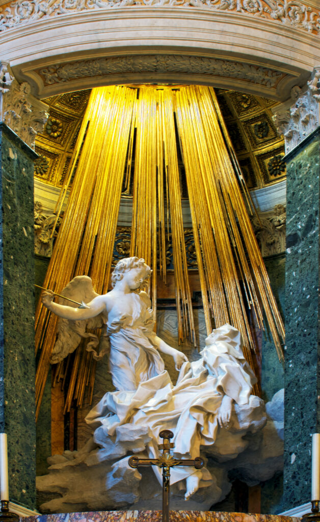 Ecstasy of St. Teresa by Gian Lorenzo Bernini. Angel with the arrow of inspiration standing above St, Theresa with rays of gold descending from above.